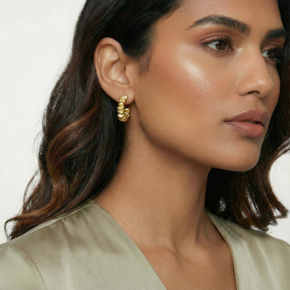 Vela Twist Hoops gold-tone earrings on a white background