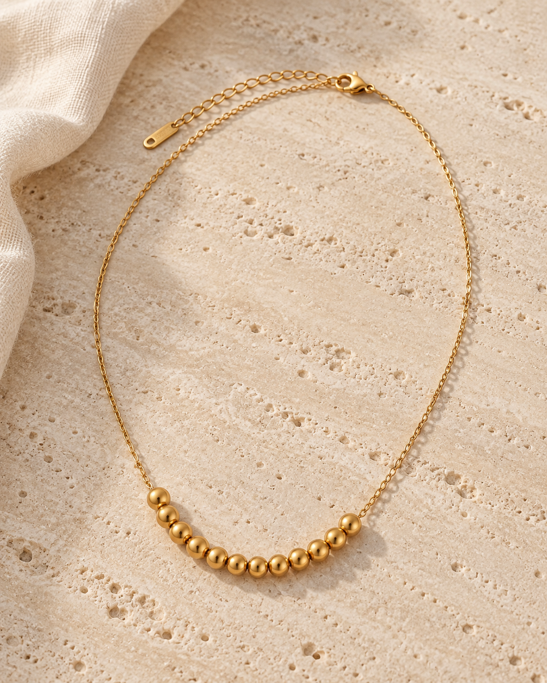 Golden Sphere Necklace gold-toned beaded necklace in a cream tone studio
