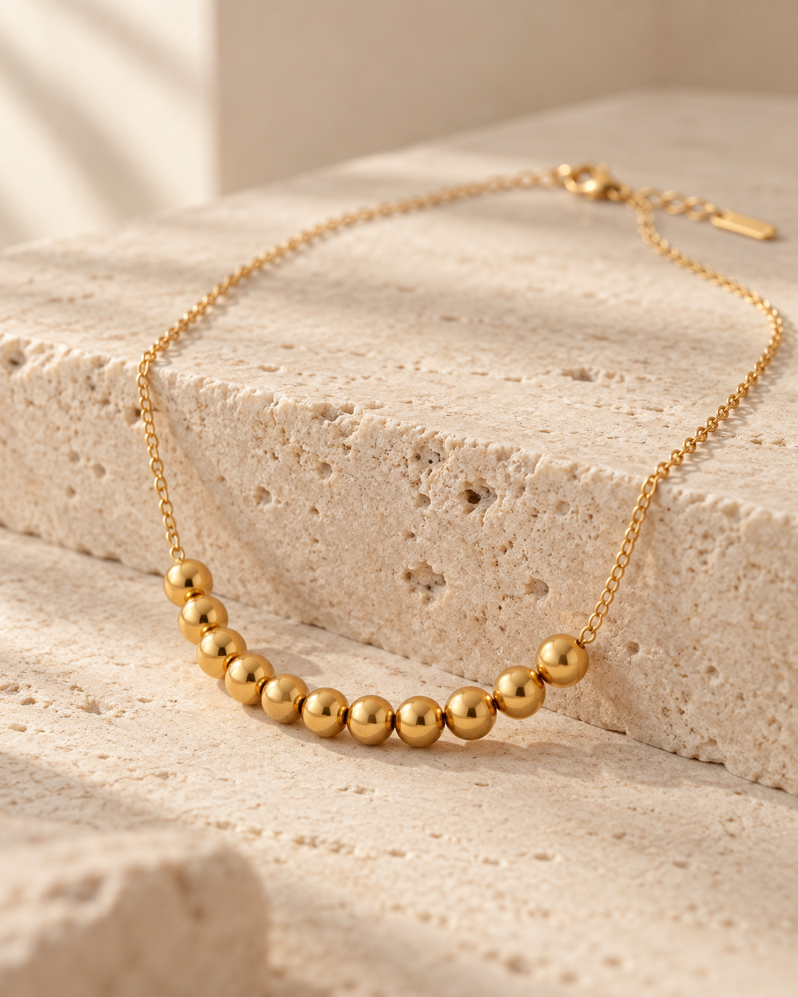 Golden Sphere Necklace gold-toned beaded necklace in a cream tone studio
