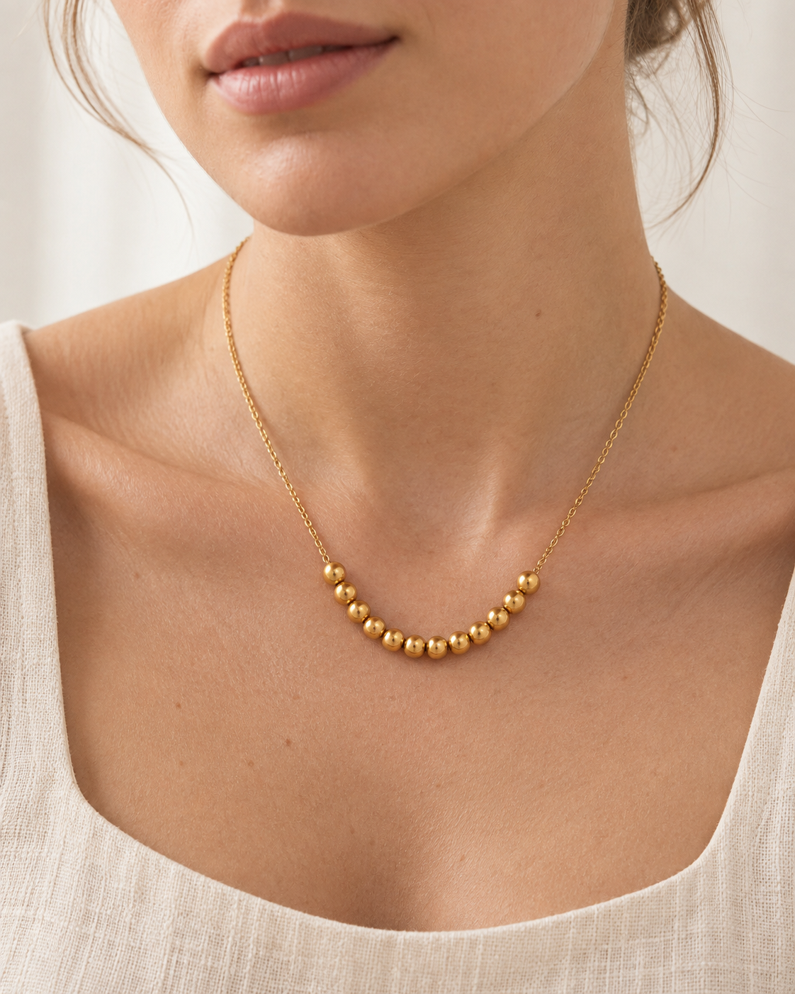 Golden Sphere Necklace gold-toned beaded necklace on a female modell