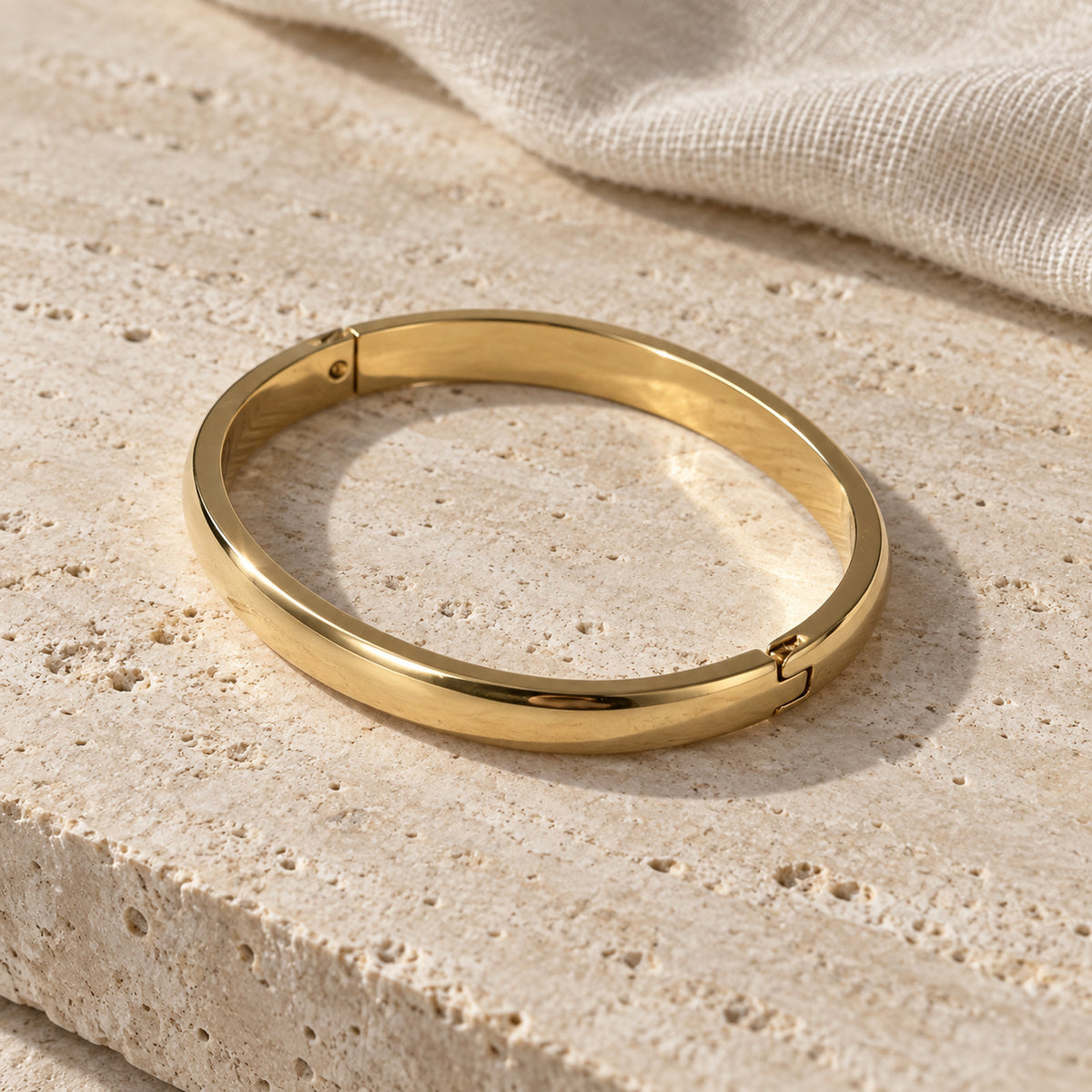 Aurelia Bangle gold-tone bracelet in a cream toned studio setting