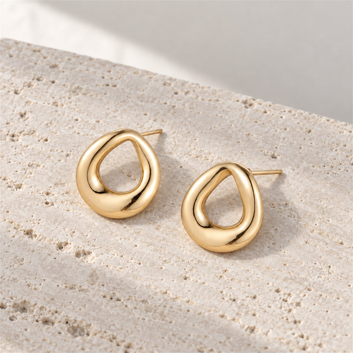 Elara Loop Studs gold-tone earrings on a white background