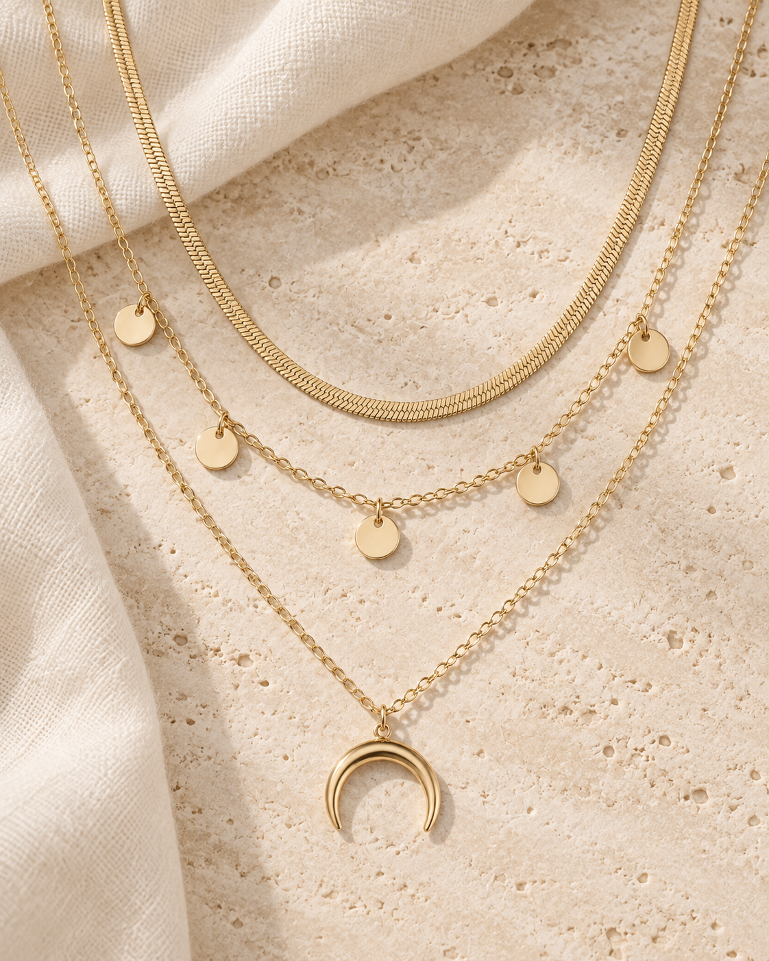 Golden Crescent Layer Set gold-tone layered necklace with on a cream studio background