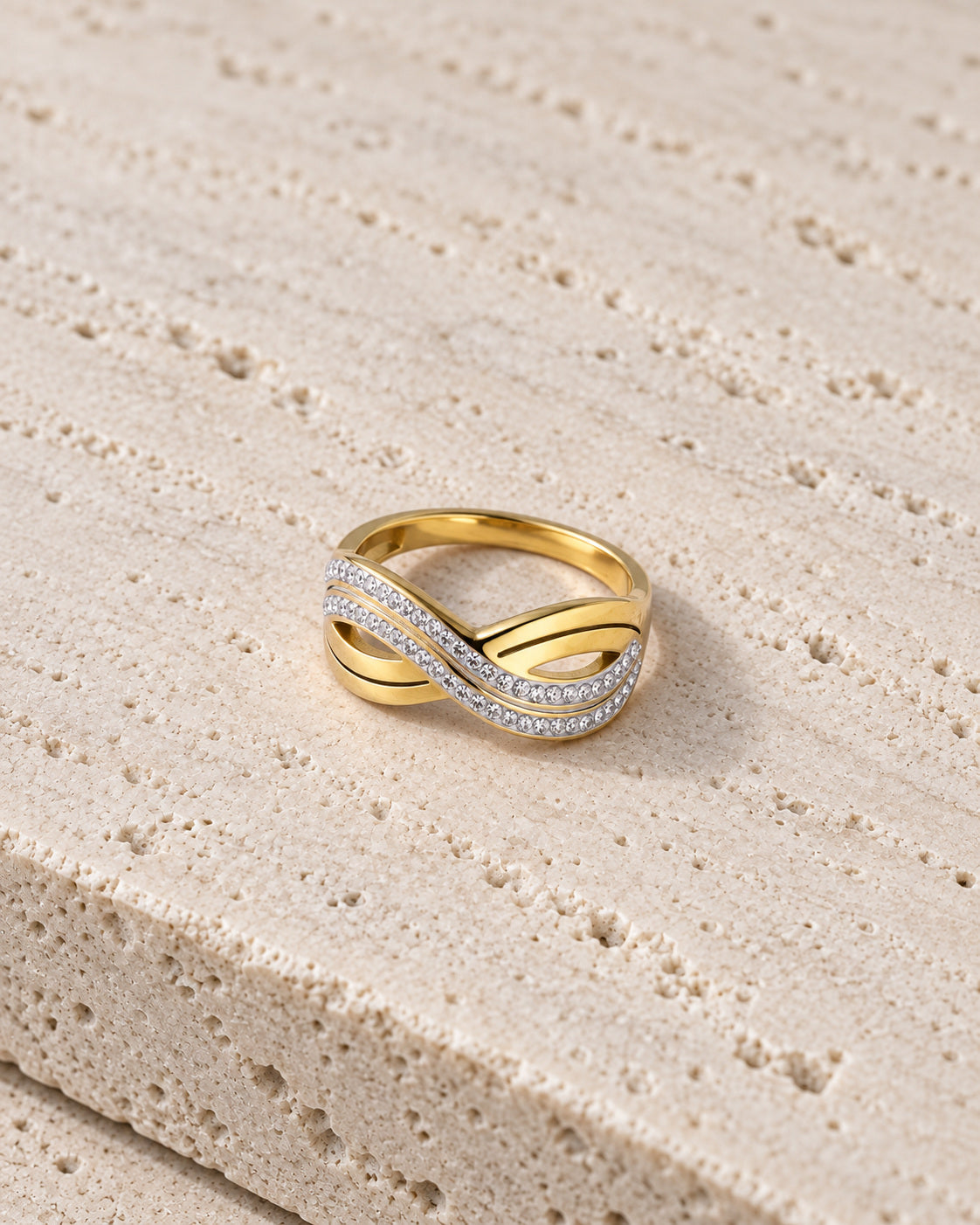 Golden Wave Flow Ring gold-tone ring in a cream coloured studio setting