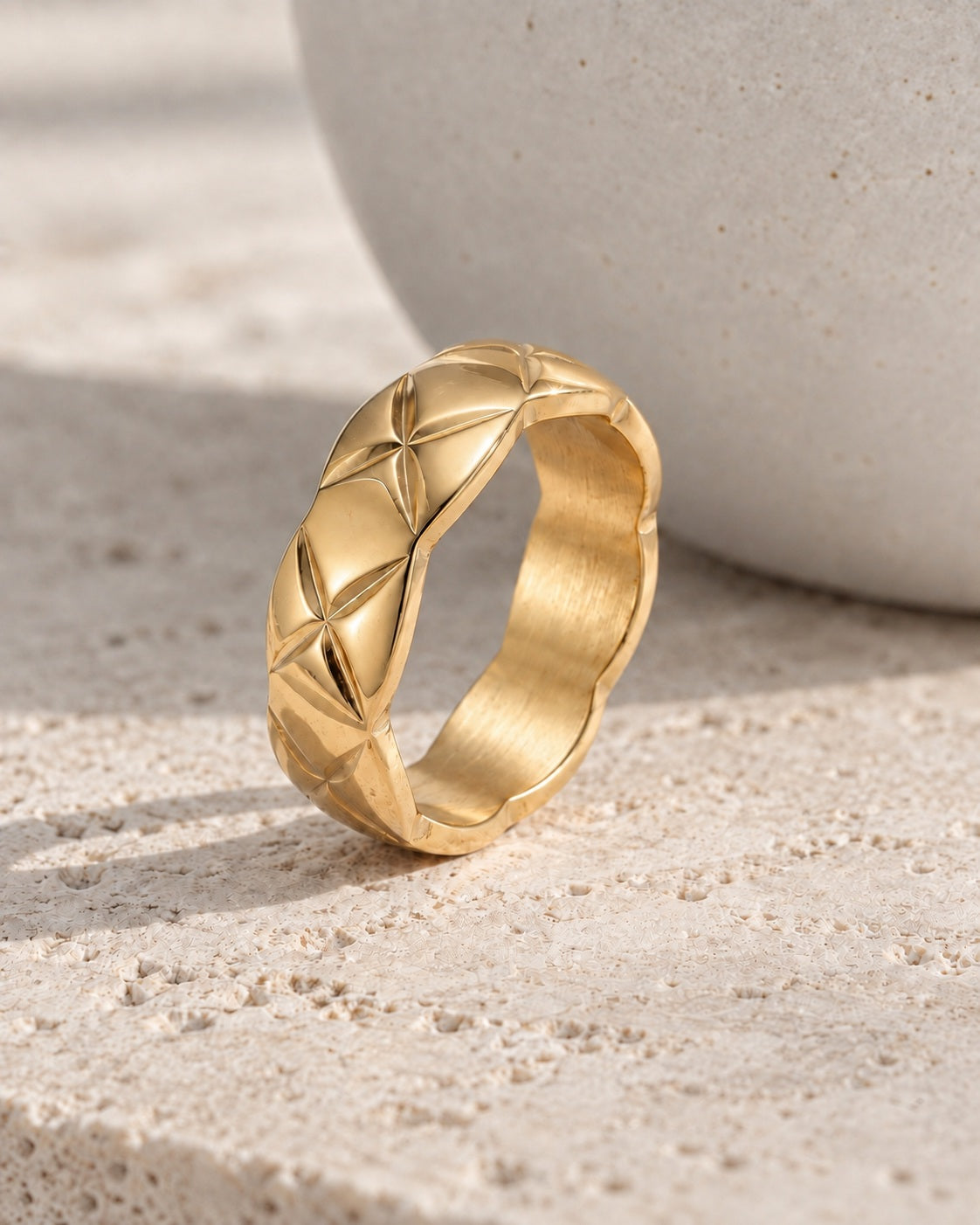 The Veria Twist Ring gold-tone band type ring on a cream studio background