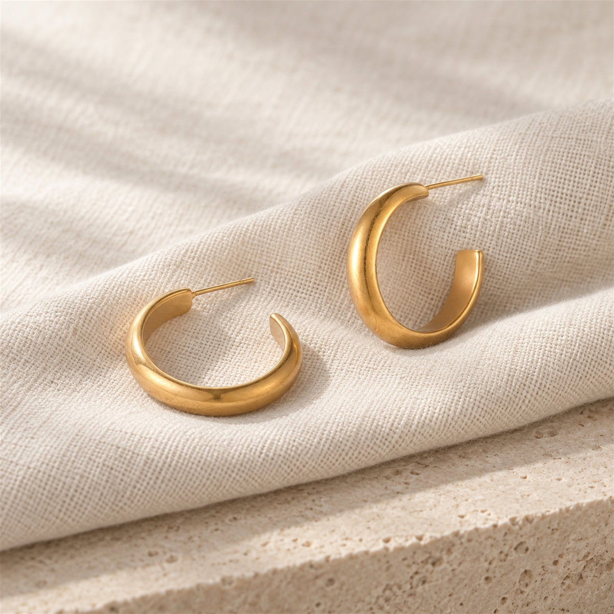Veria Solea Hoops gold-tone earrings in a cream coloured studio setting